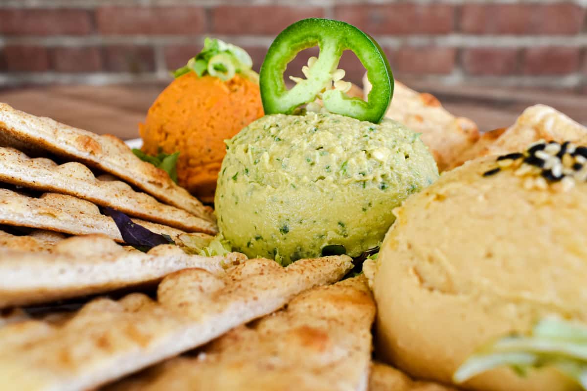 A trio of house-made traditional hummus and two rotating specialties, served with pita or fresh veggies.