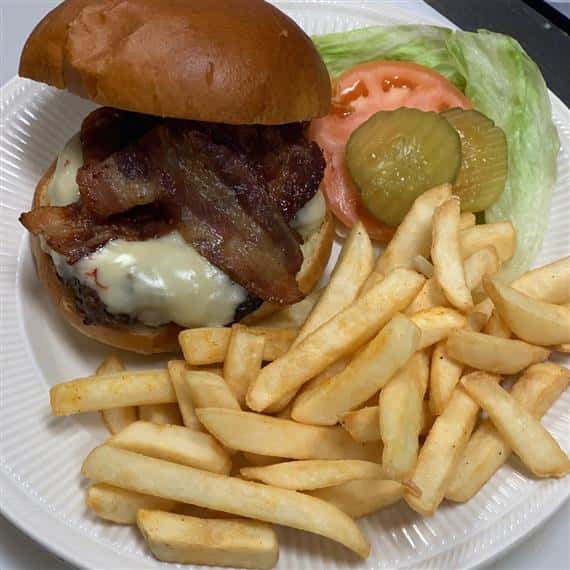 bacon cheeseburger with lettuce, tomato and pickles served with french fries