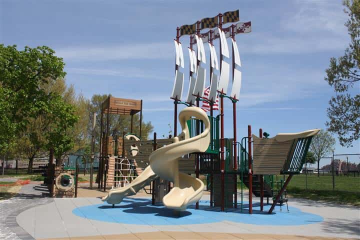 finished playground that looks like a pirate ship with slides, swings and stairs