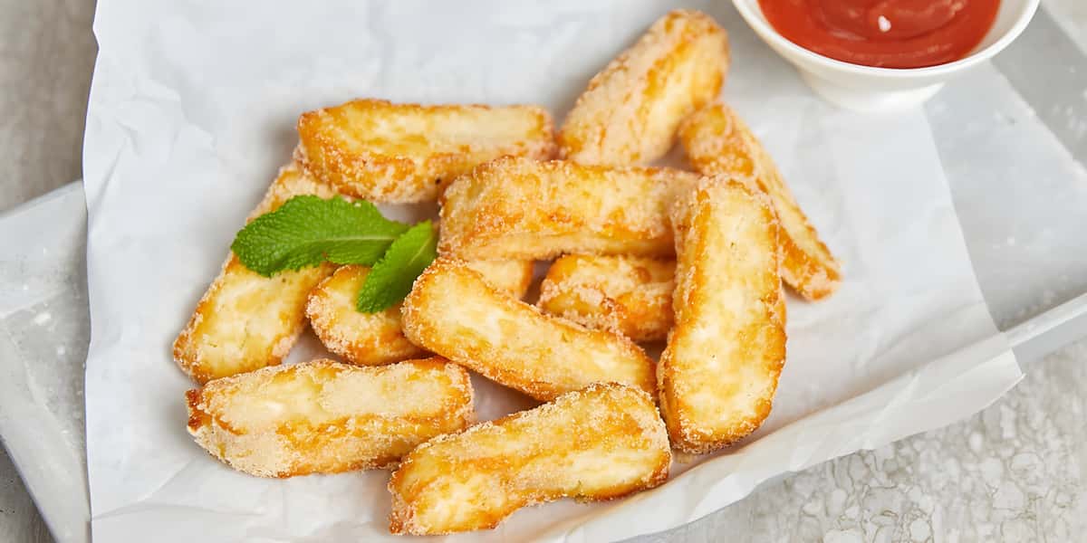 Breaded chicken strips served with dipping sauce and mint garnish.