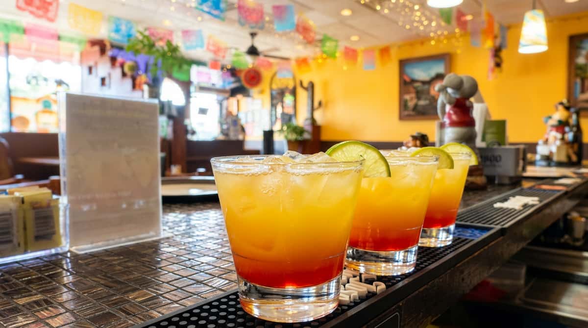 Colorful tequila sunrise cocktails served at the bar at Maya Mexican Restaurant, a festive Tex-Mex destination in Alabama.
