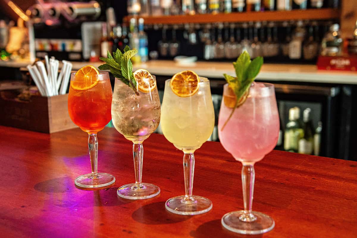 Four colorful spritz cocktails lined up at the Fin & Tonic bar in Sarasota, photographed by Florida Aesthetic Photography.