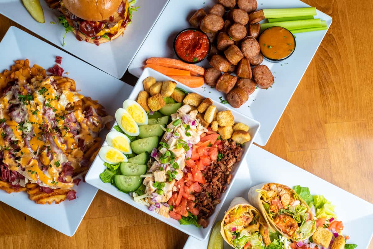 various food dishes salad wrap burger loaded fries