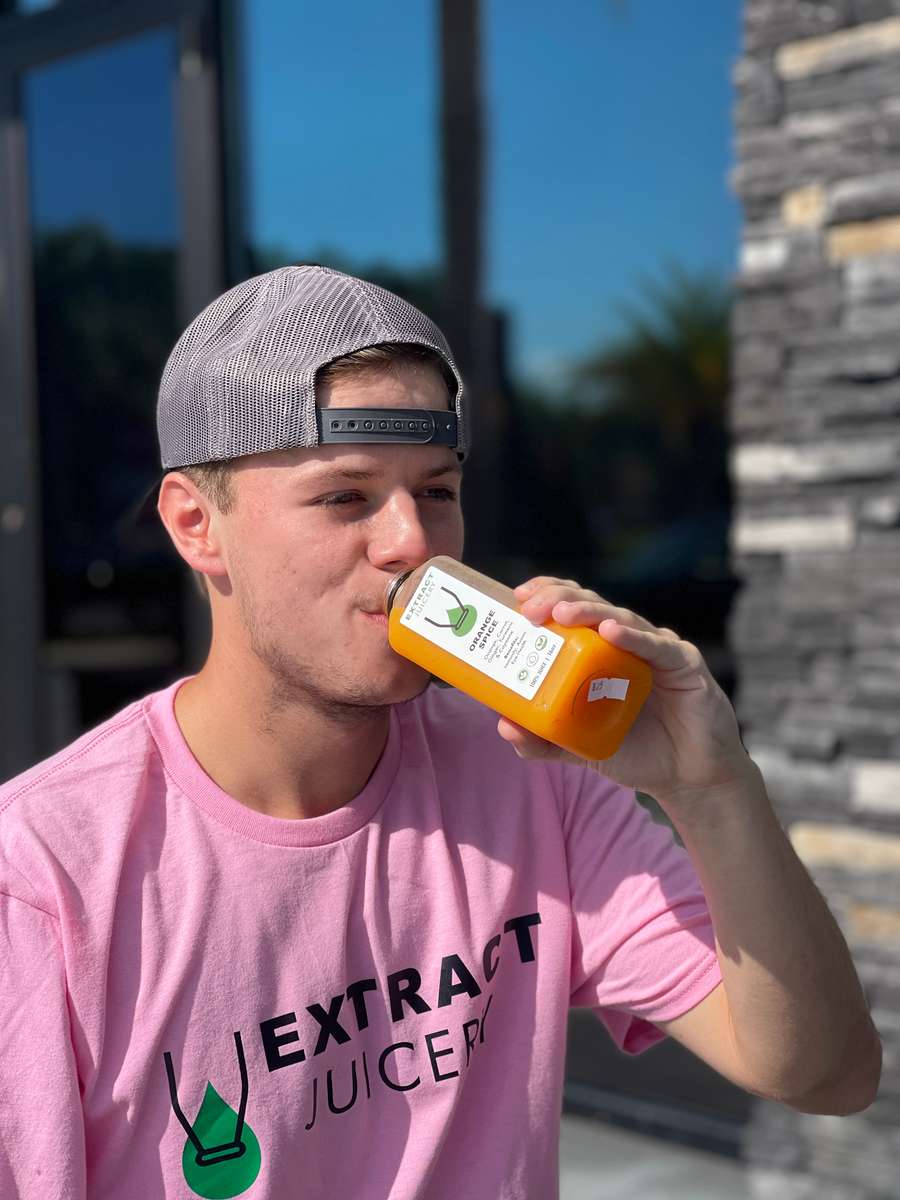 Person drinking an Extract Juicery drink
