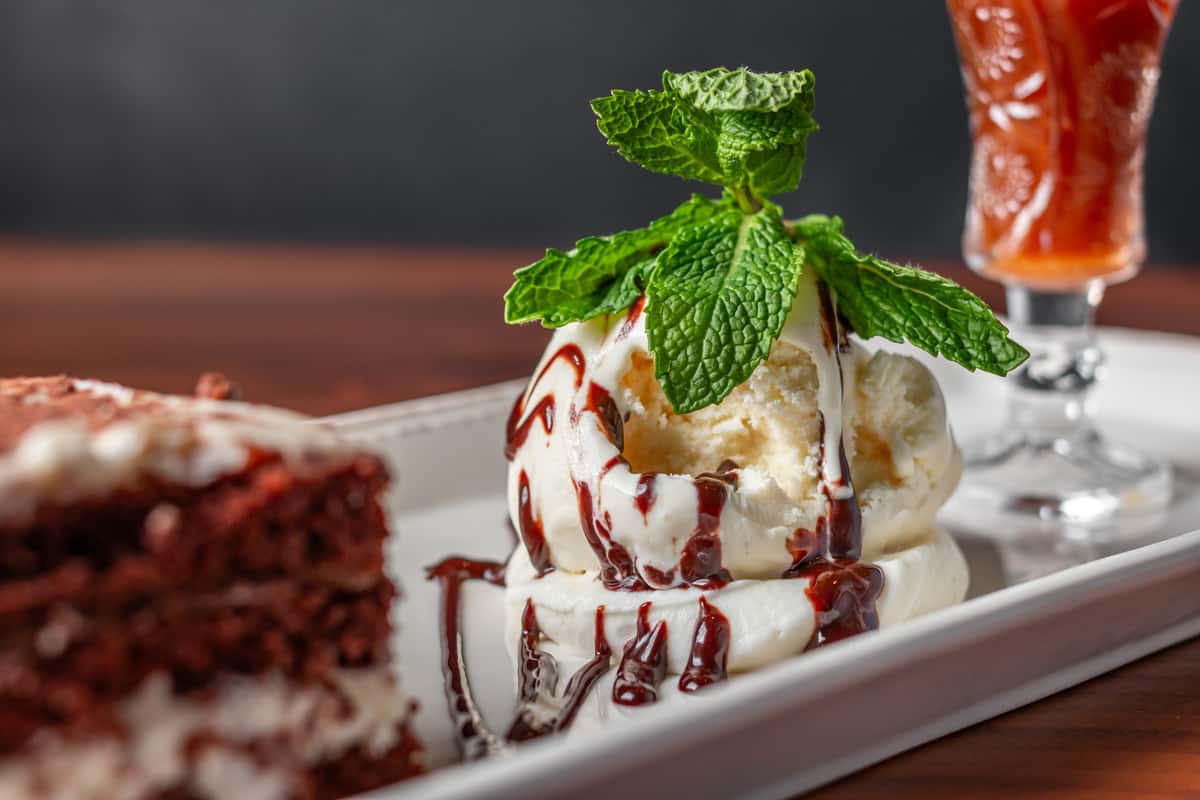 decadent dessert with vanilla ice cream drizzled in chocolate sauce and topped with fresh mint leaves
