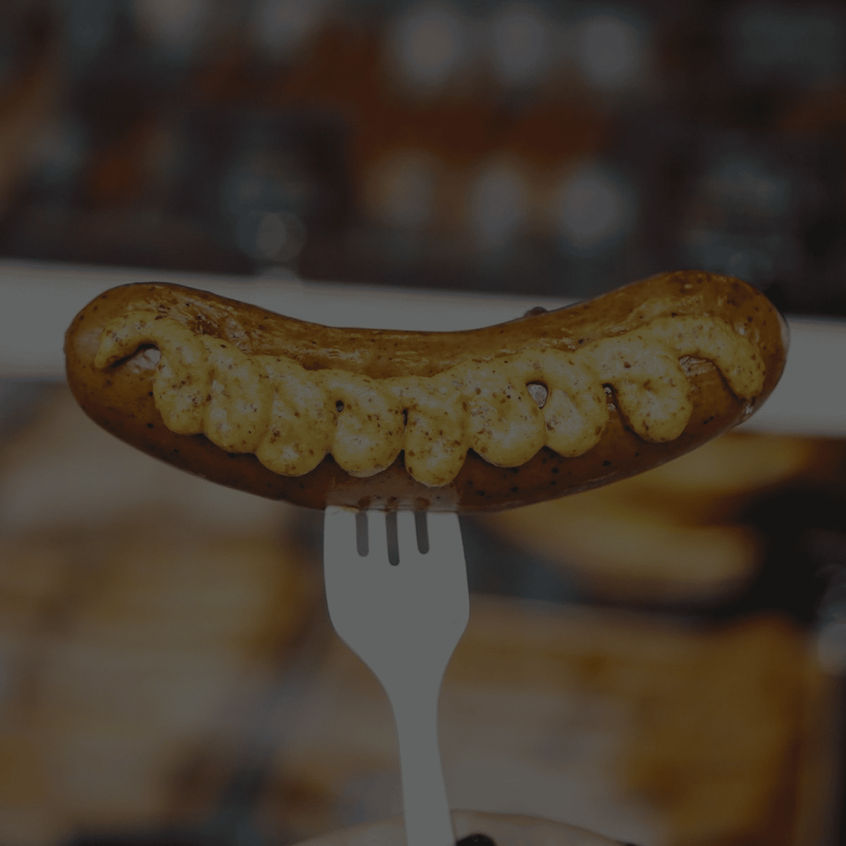 grilled sausages served with sauerkraut and dark gravy on a white plate