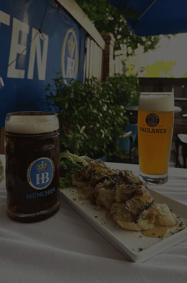 German beer served with grilled meats and herbs on an outdoor table