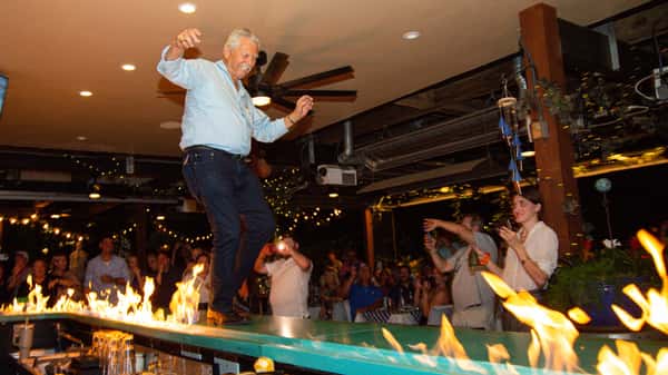 Man dancing on the bar on Fire at Taverna