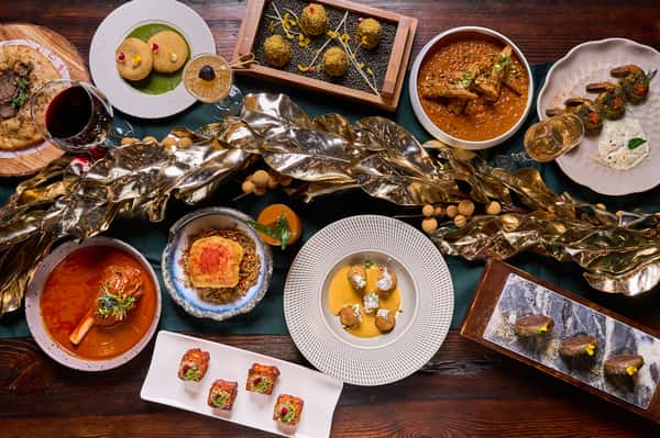 An exquisite spread of Indian cuisine featuring a variety of dishes, including rich curries, appetizers, and desserts, beautifully arranged on a decorative table setting.