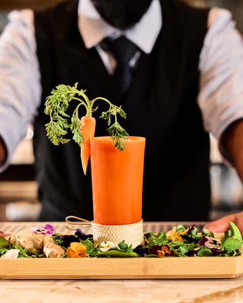 Expertly crafted cocktail garnished with a baby carrot