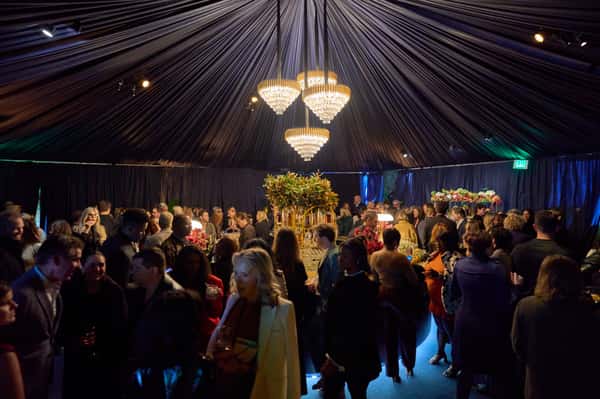 A vibrant party scene with guests mingling under colorful lights and a disco ball, creating a festive atmosphere for private events at Fitoor.