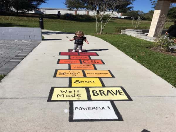 little girl paying hopscotch