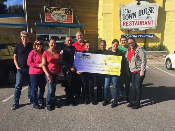 A group of people holding a check for the Oviedo Police Department