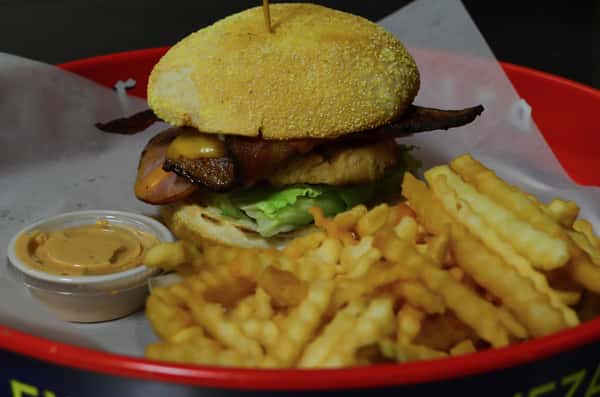 Chicken Club. Grilled chicken breast topped with bacon, ham, Swiss cheese, lettuce, tomato, and mayo. Served with a side of french fries.