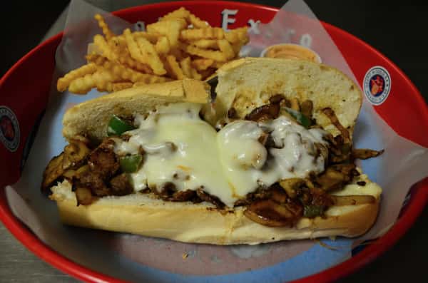 Chicken Philly. Marinated chicken topped with green peppers, onions, mushrooms, mozzarella, and mayo. Served with a side of french fries.