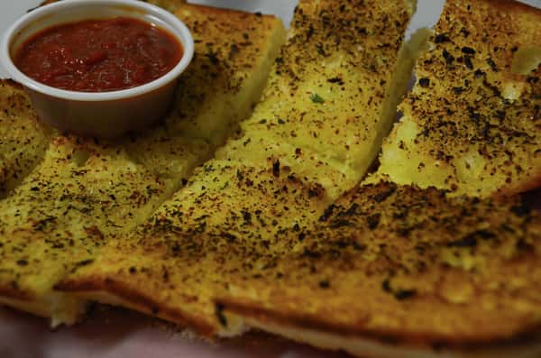 Garlic bread with a side of marinara sauce for dipping.