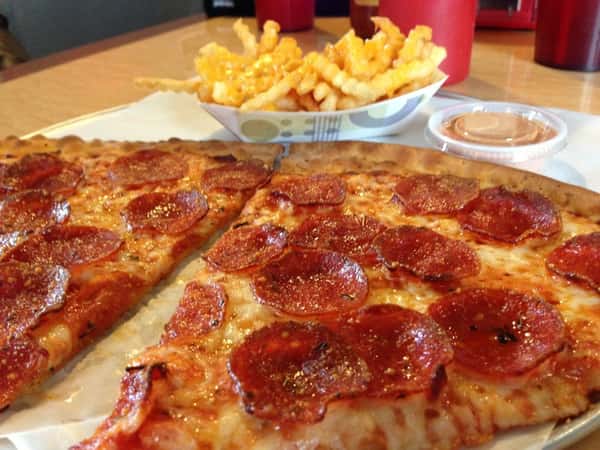 two slices of pepperoni pizza and a side of french fries.