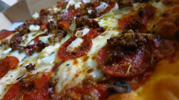 Closeup of the Combination pizza. Pepperoni, sausage, mushrooms, and onions.