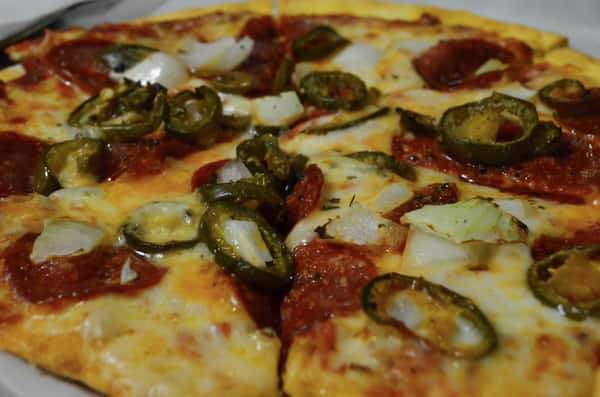 Whole pizza pie with pepperoni and jalapenos.