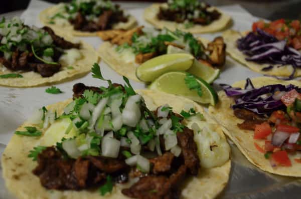 Serving dish full of a varity of differnt soft tacos.