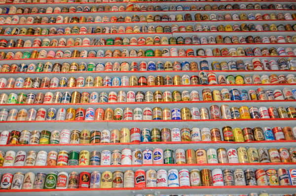 Closeup on an entire wall full of different beer cans.