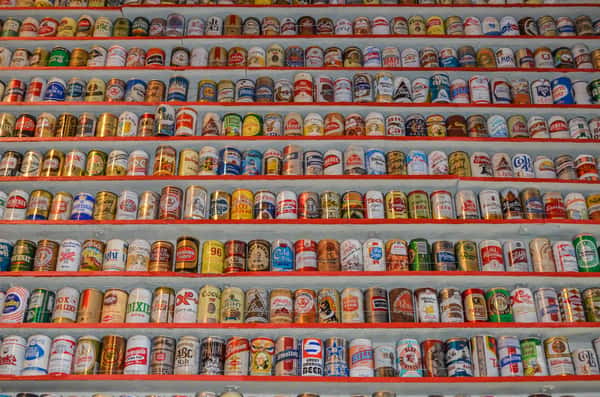 Closeup on an entire wall full of different beer cans.