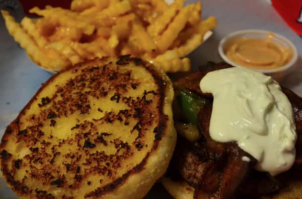 Diablo Burger. 1/3 lb. of fresh ground beef, grilled jalapenos, caramelized onions, bacon, and jalapeno cream cheese on a garlic buttered bun. Served with a side of french fries.