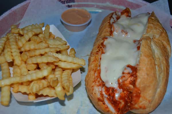 Chicken parmesan hero with a side of french fries.