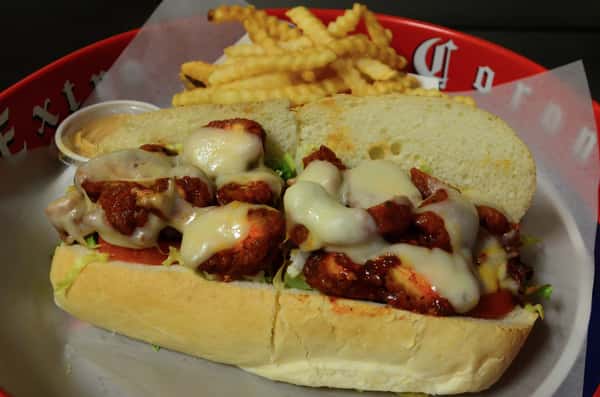 Crispy Buffalo Chicken. Crispy chicken breast tossed in wing sauce with lettuce, tomatoes, mayo and Swiss cheese. Served with a side of french fries.