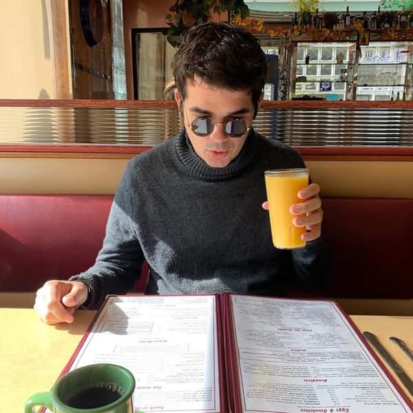 person at table with menu and juice