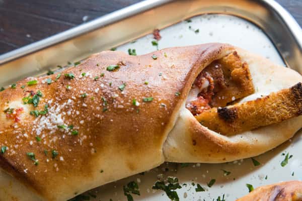 large calzone from the oven with cheese and herbs