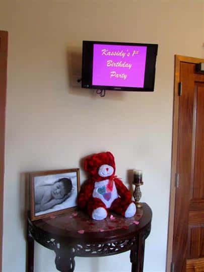 table with stuffed bear and baby picture with sign above table that reads kassidy's 1st birthday party