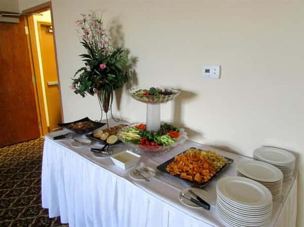 buffet table with plates and assortment of food