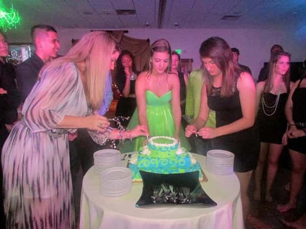 three girls putting candles on birthday cake