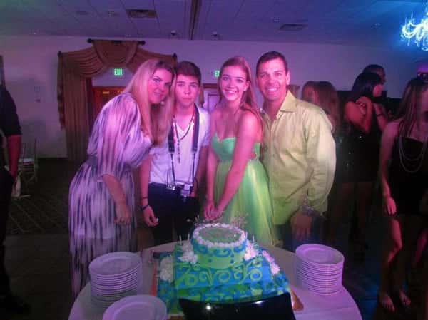 four people smiling in front of birthday cake