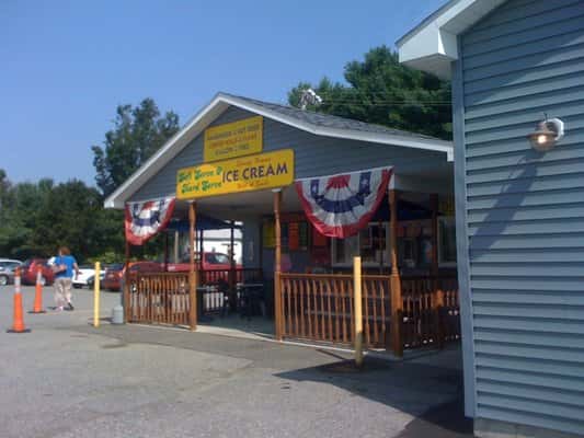 Exterior storefront of the purple cow with sign saying Ice Cream