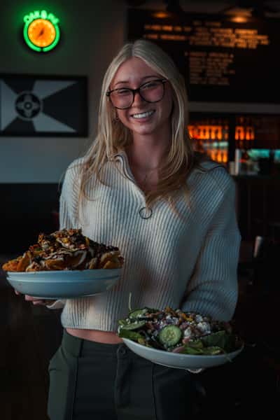 Restaurant staff member carrying fresh food at Oak & Pie in Wichita, Kansas