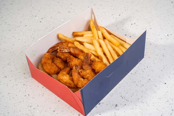 Cajun shrimp served with french fries in a red and blue takeout box.