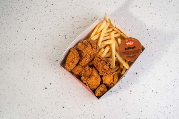 Overhead view of fried chicken tenders and french fries with dipping sauce.