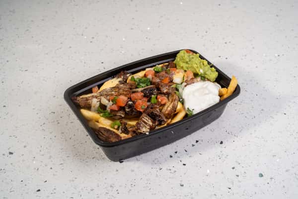 Beef fajita asada fries topped with grilled meat, vegetables, guacamole, and sour cream.