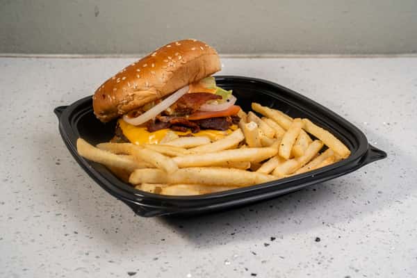 Bacon cheeseburger served with french fries in a black takeout basket.