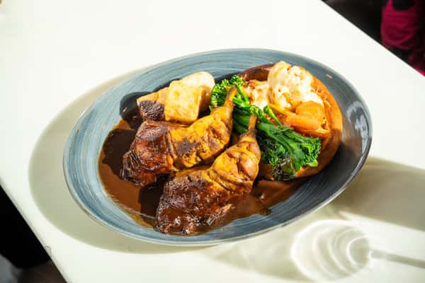 A scrumptious roast dinner featuring meat, vegetables, and gravy on a white table.