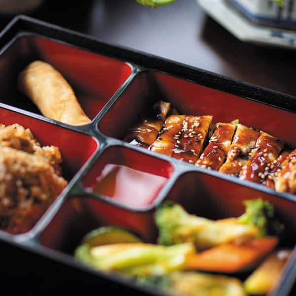 Teriyaki chicken bento box with sesame seeds, vegetables, fried rice, and spring roll