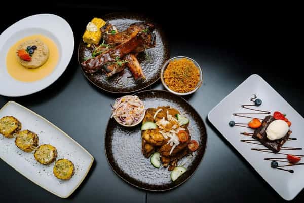 assorted grilled meats and sides served on plates in a modern casual dining presentation