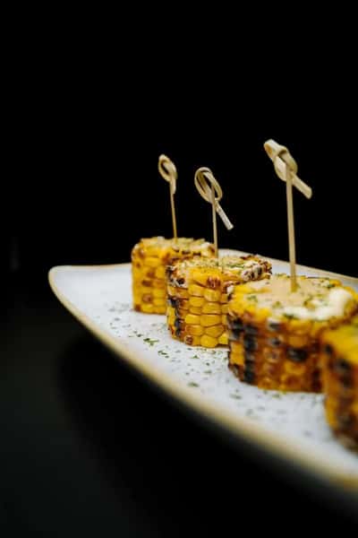 bite-sized sushi rolls plated with toothpicks on a white dish in a modern restaurant