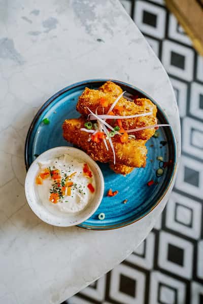 golden fried chicken bites served with creamy dipping sauce on a colorful plate