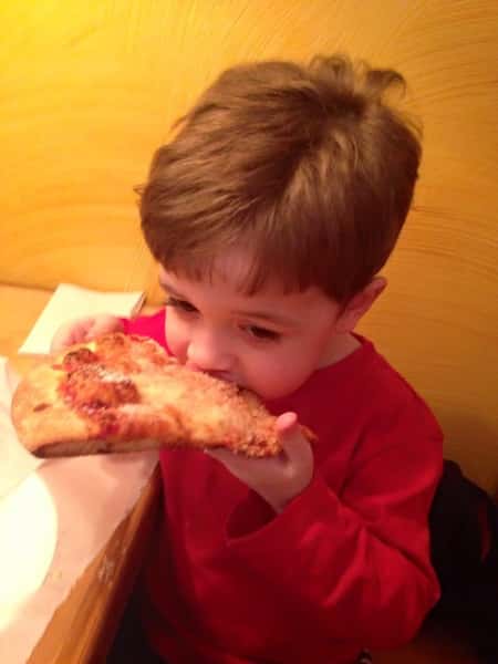 A child eating a slice of pizza