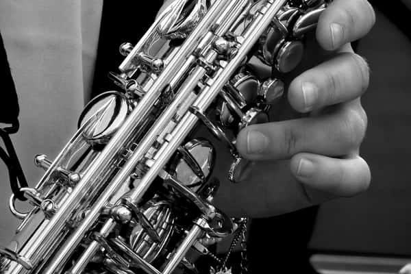 Black and white close-up photo of a hand holding a saxophone