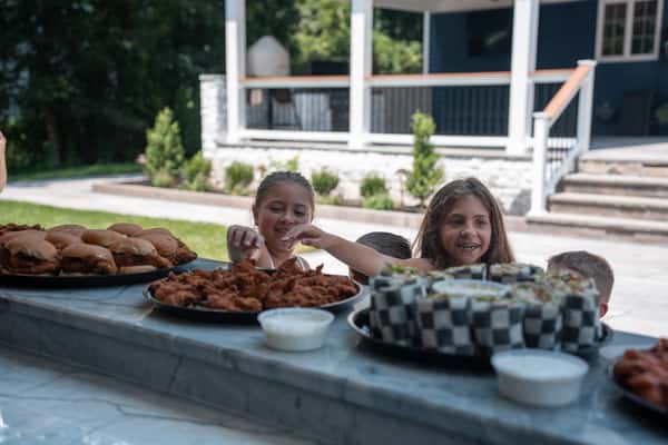 Children picking up food from a catering tray