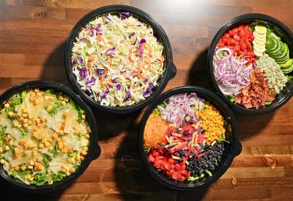 Four large bowls of salad